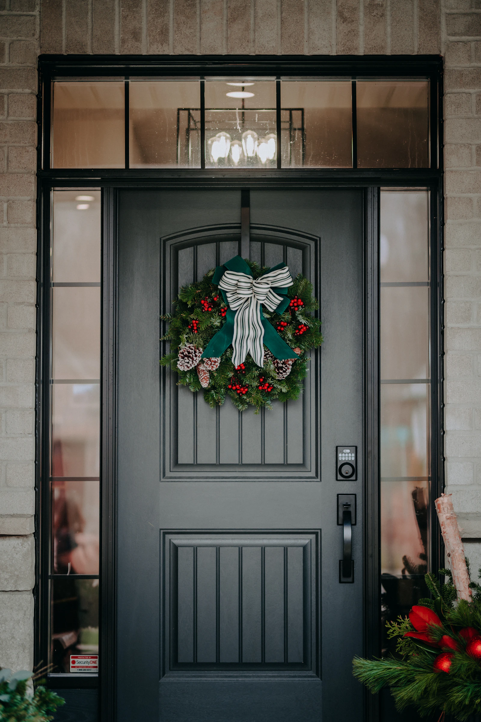 Evergreen Christmas wreath with a bow on a dark front door