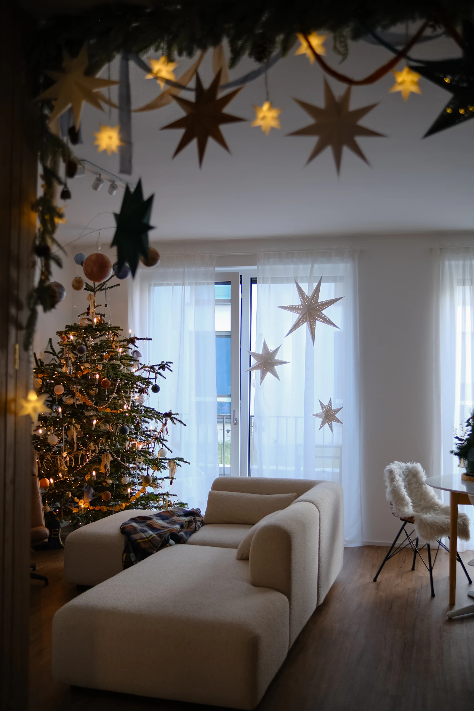 Living room decorated with a Christmas tree and hanging star ornaments